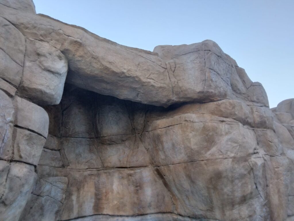 Detail of realistic artificial rock showing layered strata, fractures and earth-tone coloring